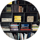 Photo of books and audio equipment neatly arranged on bookshelf.